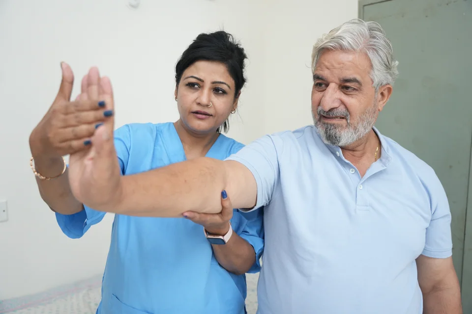 A physiotherapist guiding a patient through an arm mobility exercise